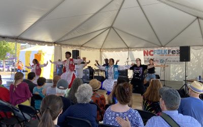 A small group of Bhangra dancers perform in an outdoor stage during the Folk Festival