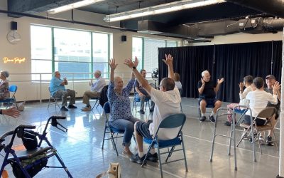 A dance studio full of older adults mirror each other during an exercise in the Dance Project class for Parkinson's.