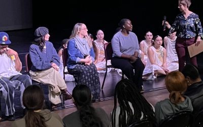 Several choreographers sit at the front of a stage during a Q&A after the NC Dance Festival's show for school groups.